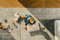 Bambino su tappeto con federa cuscino anni 70